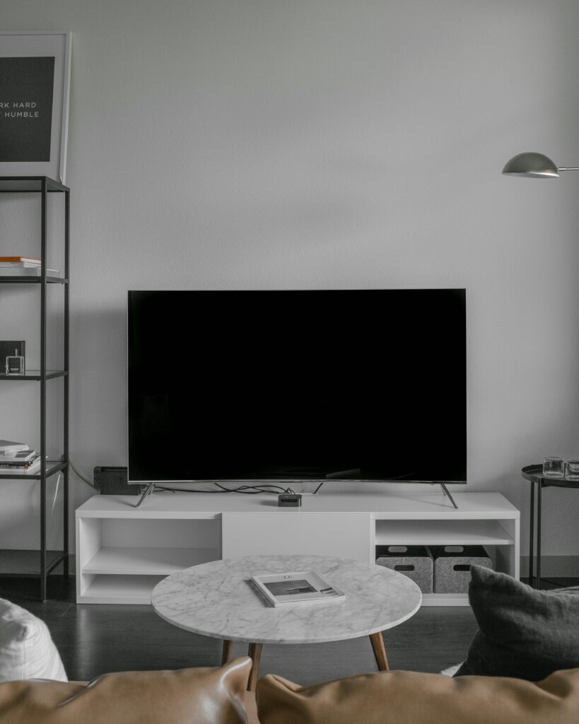 a flat screen TV on a white console table in a living room.